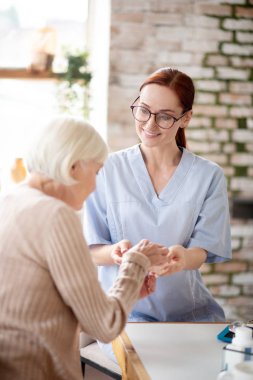 Hastaya hap veren gözlük takan sağlık görevlisi