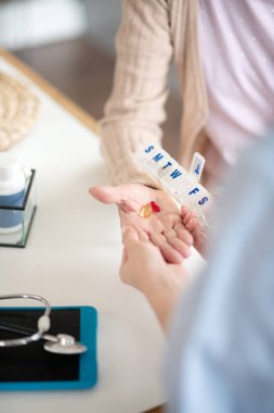 Emekliye iki hap veren hemşirenin üst görünümü