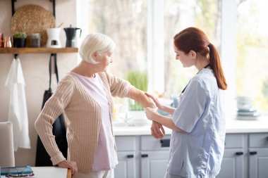 Bakım kızıl saçlı hemşire kadın için kol jel koyarak