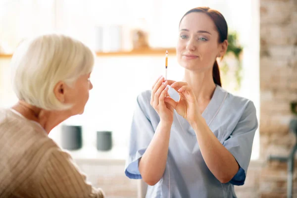 Infirmière tenant la seringue avant injection pour pensionné — Photo