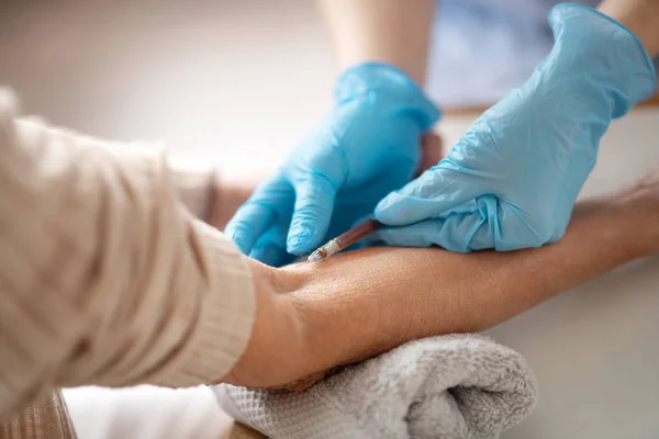Крупный план медицинского работника в перчатках, делающего укол — стоковое фото
