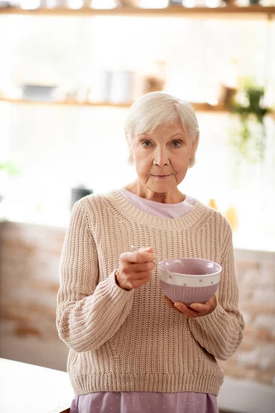 朝にオート麦を食べる暖かいセーターの女性 — ストック写真