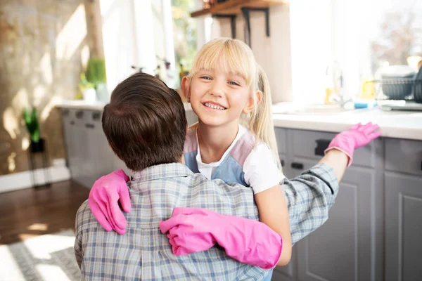 Beaming córka przytula tatusia po sprzątaniu kuchni — Zdjęcie stockowe
