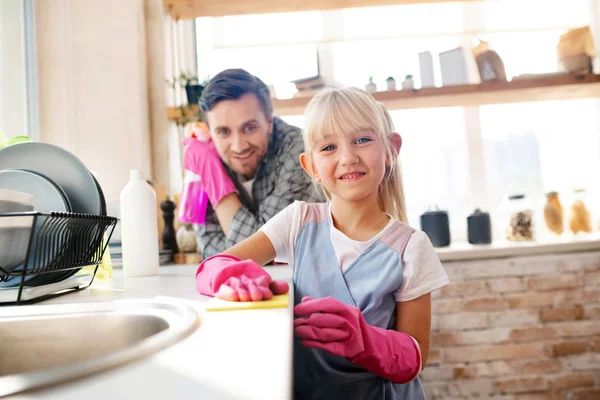 Fröhliches Mädchen mit rosa Handschuhen hilft Papa beim Putzen — Stockfoto