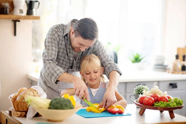 Father and daughter slicing peppers before making stew — ストック写真