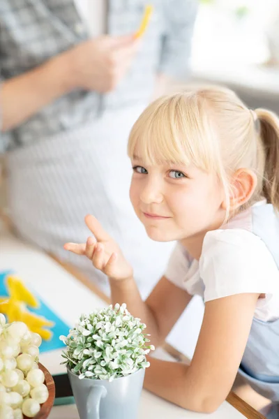 Blå-ögd flicka står nära bordet i köket — Stockfoto