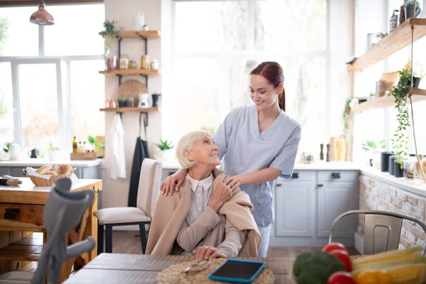 Pensionnée âgée se sentant reconnaissante envers sa soignante agréable — Photo