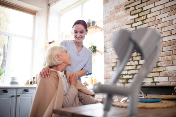 Junge Pflegerin in Uniform spricht mit Patientin — Stockfoto