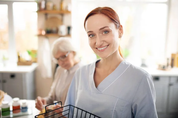 Hermosa cuidadora sonriente disfrutando de su trabajo — Foto de Stock