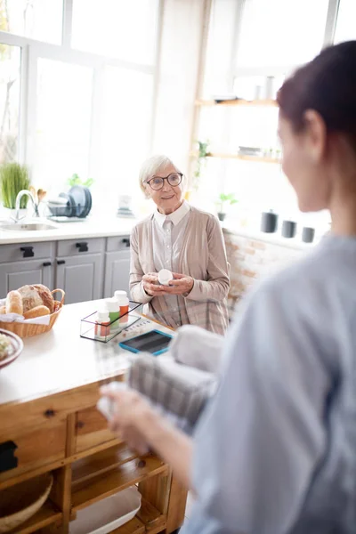 Rentnerin mit Brille spricht mit Pflegerin — Stockfoto