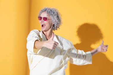 Mutlu ve heyecanlı bir kadın başparmağını kaldırıyor.