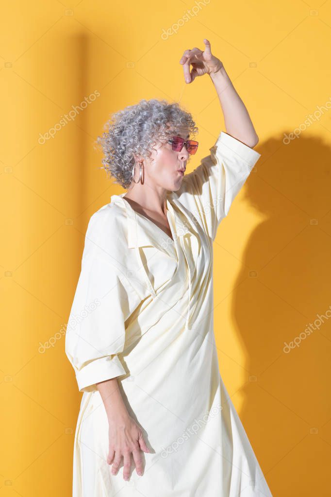 Curly woman wearing long dress showing funny poses