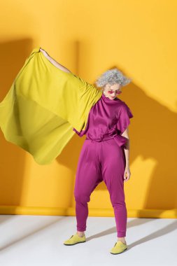 Parlak pembe elbiseler giyen kıvırcık olgun bir model.