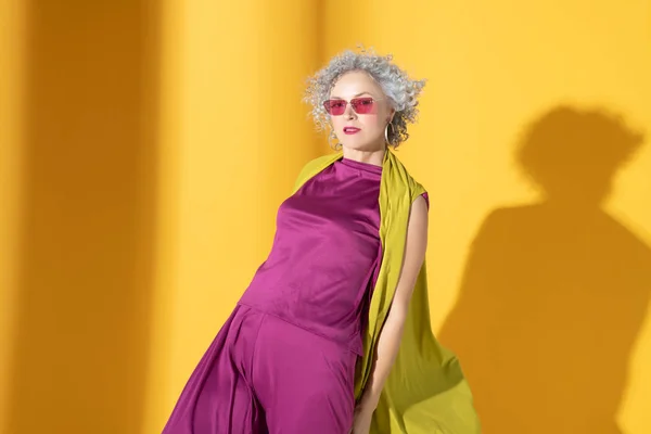 Mujer rizada de pelo gris con traje rosa y gafas —  Fotos de Stock