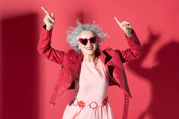 Donna in abito rosa e giacca rossa in movimento e ridendo — Foto Stock