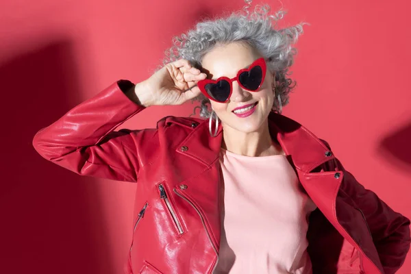 Zelfverzekerde vrouw met heldere lippen met een rode bril — Stockfoto