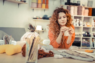 Rahatlamış genç kadın yeni yumuşak ipliği test ediyor.