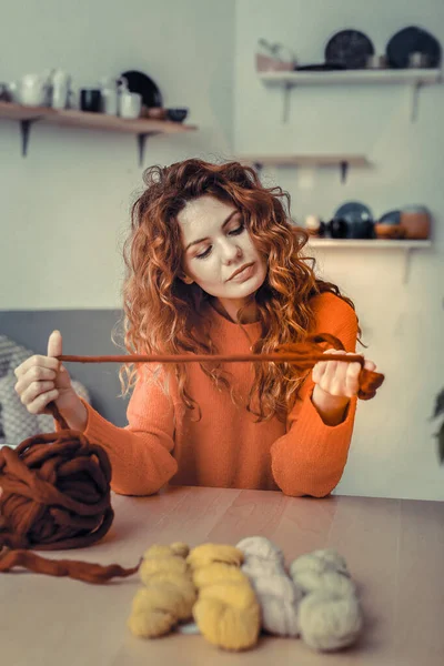 Koncentrált, fiatal, hosszú hajú, puha fonalat tartó ezermester — Stock Fotó