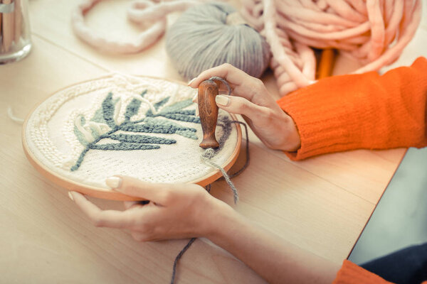 Сфокусированное фото на кружевной рамке, находящейся в женских руках
