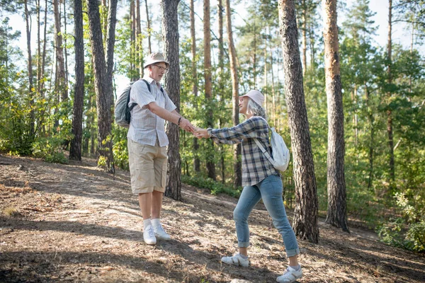 Pareja de adultos maduros con mochilas caminando en el bosque —  Fotos de Stock