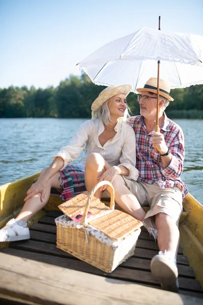 Pareja sentada en un pequeño bote y disfrutando de un viaje por el río —  Fotos de Stock