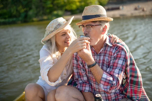 Bearded husband drinking tea having boat trip with wife — Stock Photo, Image