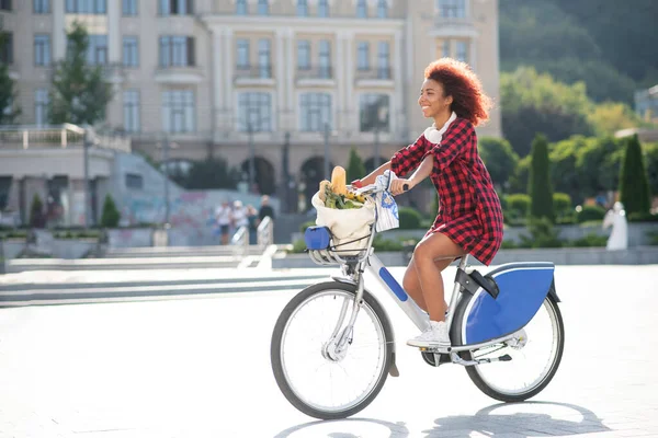 Mujer de pelo rojo rizado montar bicicleta después de ir al supermercado — Foto de Stock