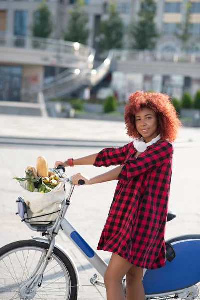 Woman coming back home after buying bread and veggies