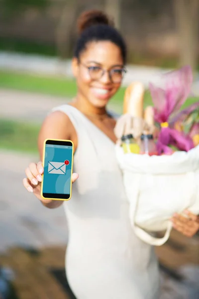 Mujer sosteniendo teléfono inteligente después de recibir un mensaje de un amigo —  Fotos de Stock