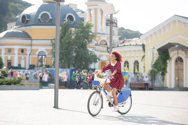 Кучерявий рудий студент їде на велосипеді в теплий сонячний день — стокове фото