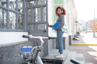 Kulaklık takan bir öğrenci. Kulaklık takan öğrenci dersten sonra postaneye giriyor.