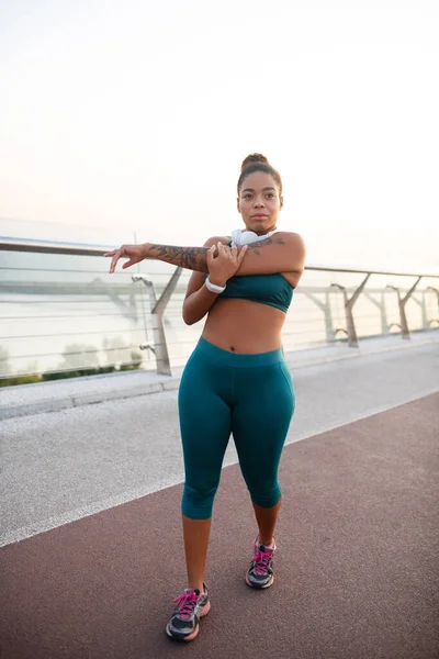 Nő túlsúlyos kinyújtja a karját edzés közben — Stock Fotó