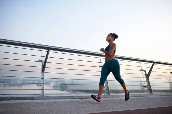 Mujer de piel oscura con polainas disfrutando de la carrera matutina — Foto de Stock