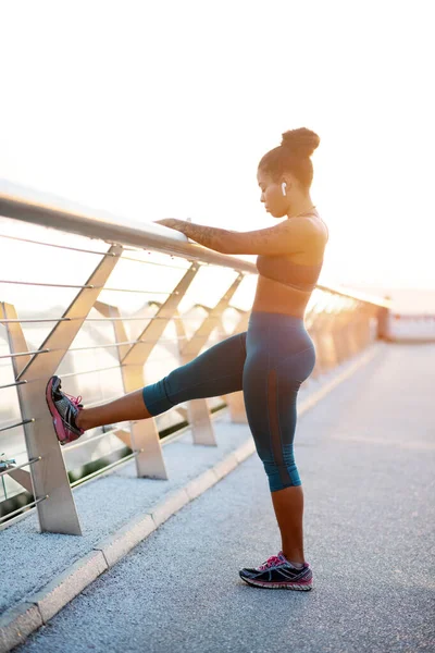 Mujer con exceso de peso estirando las piernas después de correr — Foto de Stock