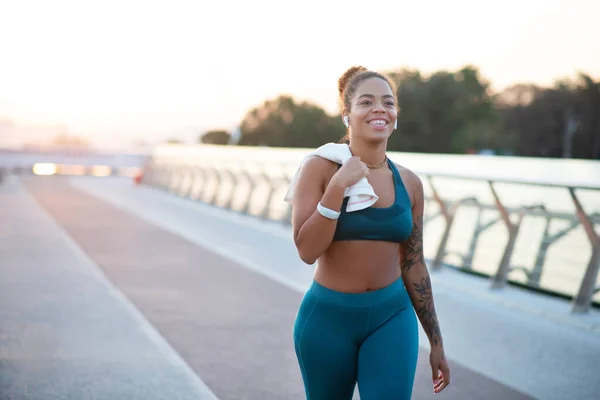 Mujer joven tatuada volviendo a casa después de correr por la mañana — Foto de Stock