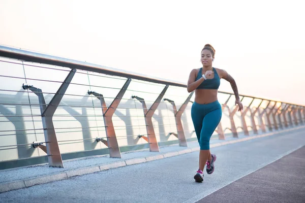 Mujer joven de piel oscura con sobrepeso corriendo muy rápido — Foto de Stock