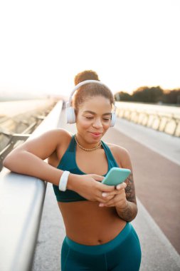 Esmer tenli kadın koşuya başlamadan önce müziği açıyor