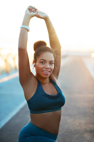 Mujer de ojos oscuros estirando su cuerpo antes de comenzar el entrenamiento —  Fotos de Stock