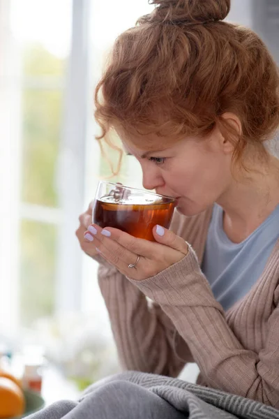 Mujer enferma bebiendo té con limón mientras tiene fuerte — Foto de Stock