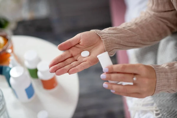 Kvinna som håller vita piller medan lider av huvudvärk — Stockfoto