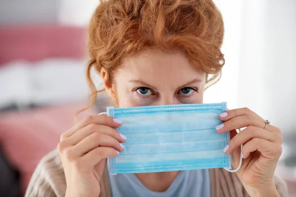 Woman using protective mask not to infect her family — Stock Photo, Image