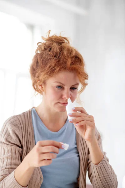 Mulher tomando spray nasal enquanto tem espirros insuportáveis — Fotografia de Stock