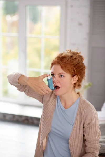 Woman having asthma using inhalator while feeling bad — Stock Photo, Image