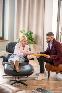 Sakallı psikolog, anksiyetesinde kadına yardım ediyor.