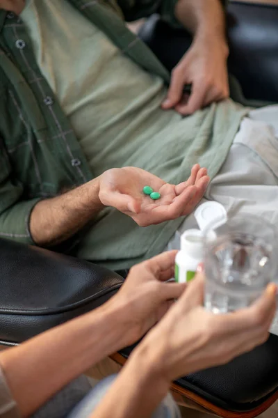 Close up of psychoanalyst giving pills and water to her client — Stock Photo, Image