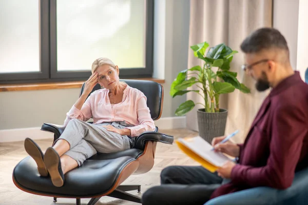 Skäggig psykolog med glasögon som lyssnar på mogen kvinna — Stockfoto