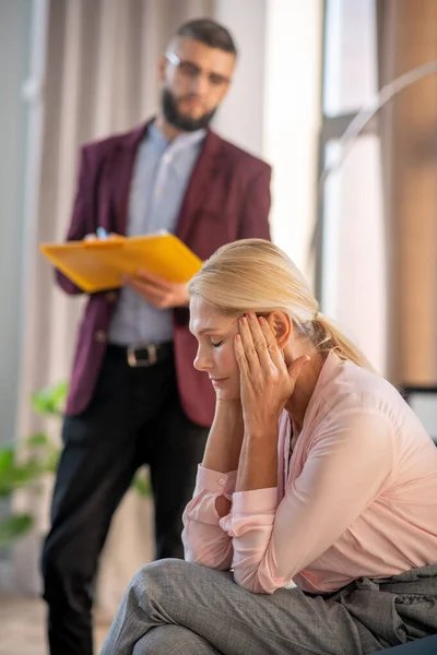 Blonde woman feeling confused while visiting psychoanalyst — Stock Photo, Image