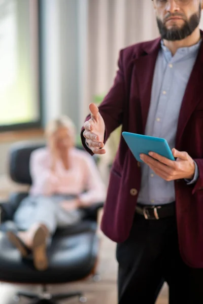 Close up of bearded psychologist reaching hand to greet patient