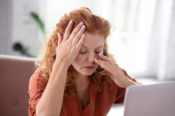 Rödhårig frilansare som lider av huvudvärk under arbetet — Stockfoto