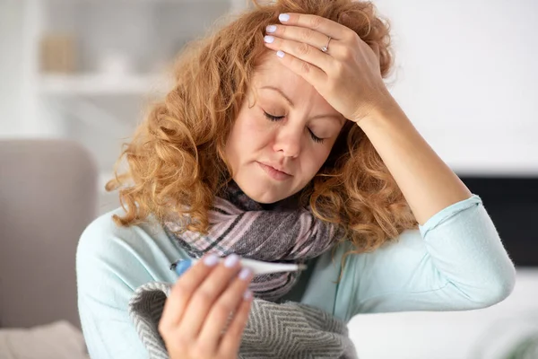 Woman feeling terrible while touching her forehead and having fever — Stock Photo, Image